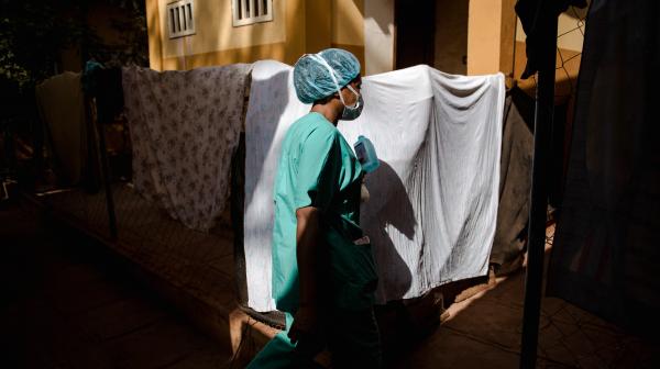 The MSF nurse supervisor walks through the Centre de Traitement Epidemiologique in Siguiri, Guinea.